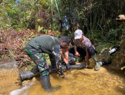 Babinsa Koramil Aradide dan Satgas Pamtas Yonif Baladibya Yudha Bersihkan Penampungan Air dan Saluran Pipa